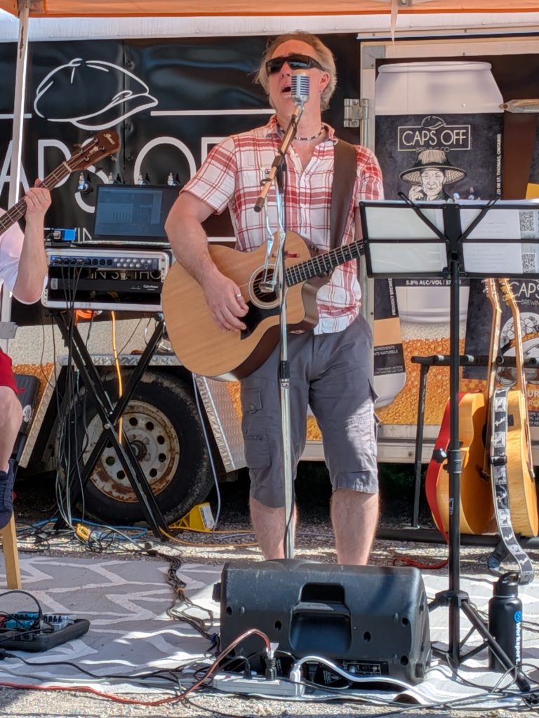 John, vocalist and guitarist in Boxcar Junction, singing at a microphone.