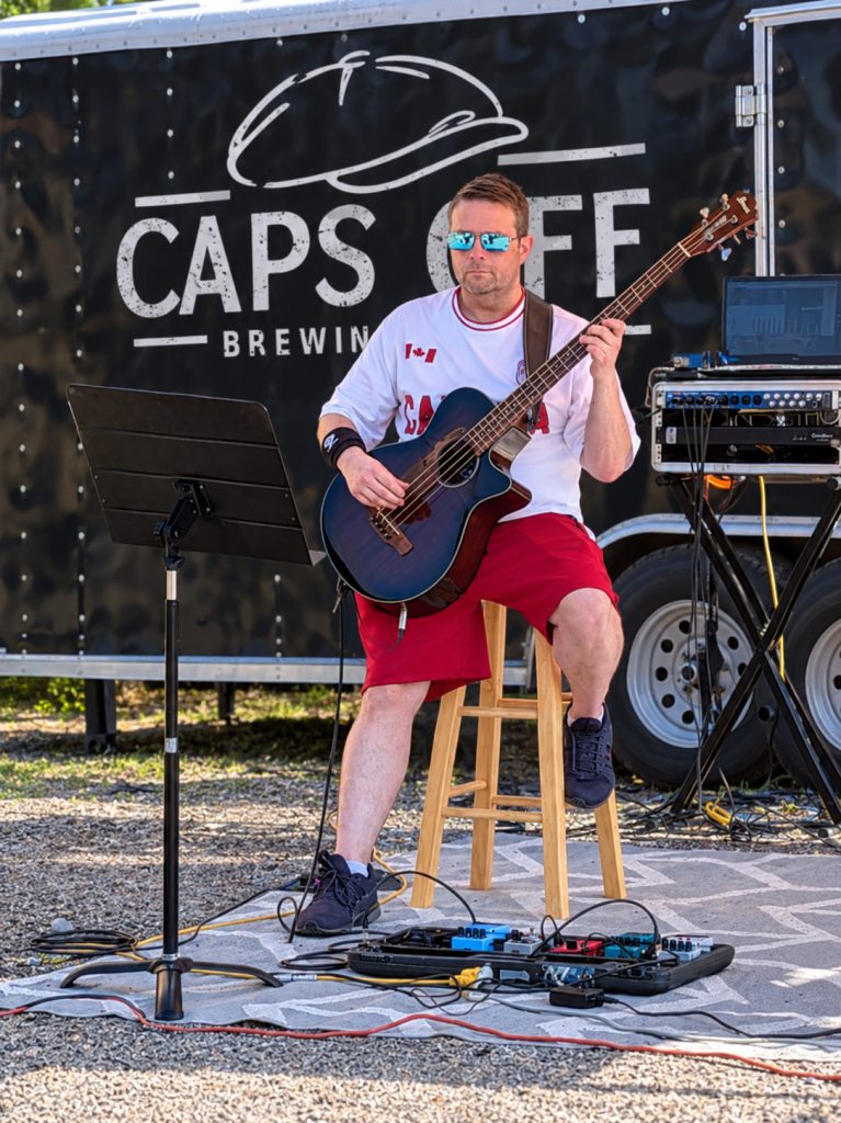 Joel, bassist in Boxcar Junction, seated and playing bass.